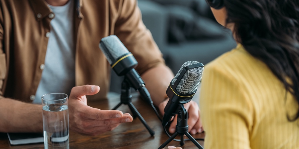 Cropped View Of Two Radio Hosts Recording Podcast In Broadcasting Studio