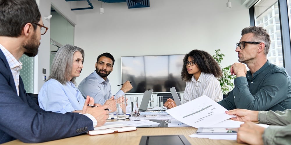 Diverse Professional Executive Business Team People Discuss Project Sitting At Meeting Table In Boar