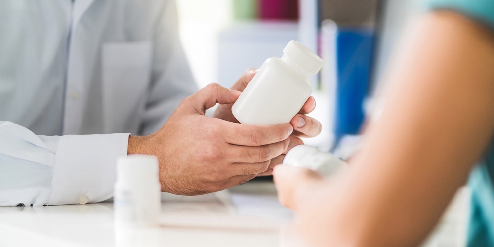 Doctor Consulting Patient About Right Medication. Physician Holding Medicine And Pills In Hand. Phar
