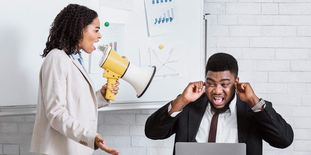 Enraged Female Boss With Loudspeaker Screaming At Her Scared Subordinate At Company Office. Frighten
