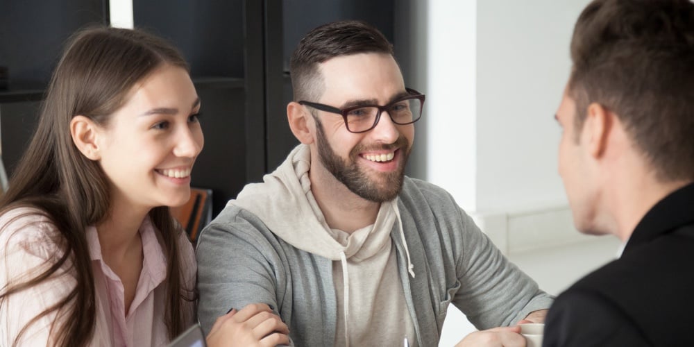 Excited Smiling Millennial Couple Discussing Mortgage Loan Investment Or Real Estate Purchase With R