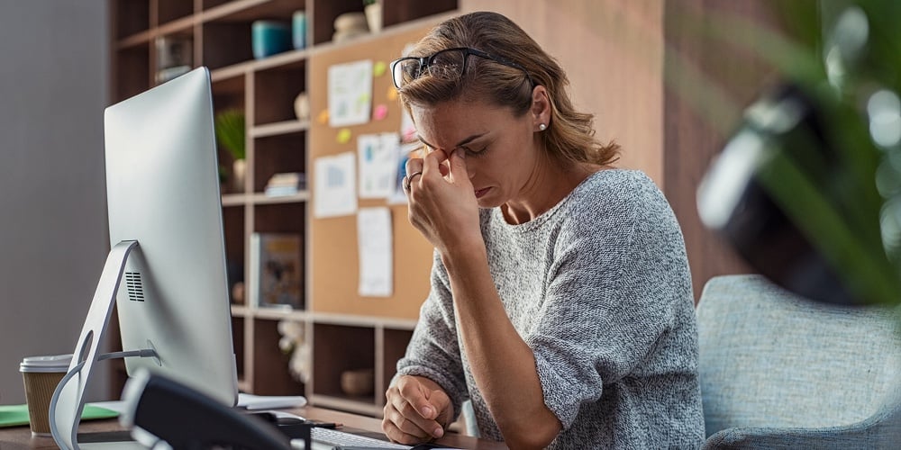 Exhausted businesswoman having a headache at office. Mature creative woman working at office desk fe