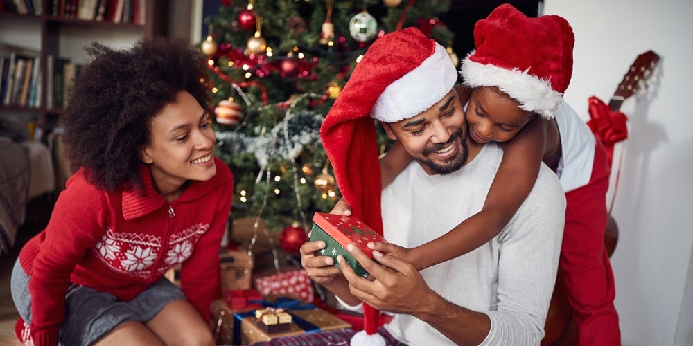 Family Celebrating Christmas Together.Smiling father and his daughter open Christmas gift