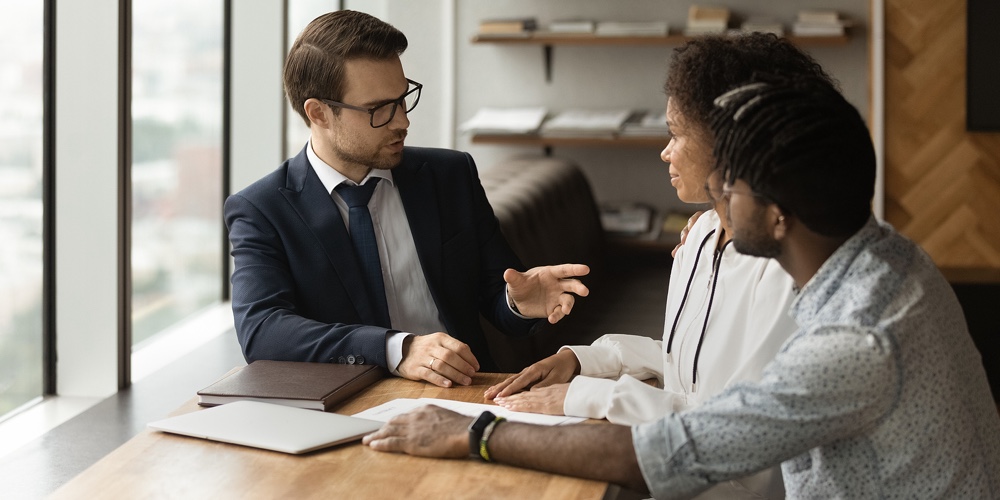 Family Financial Advisor Consulting To African Couple During Meeting