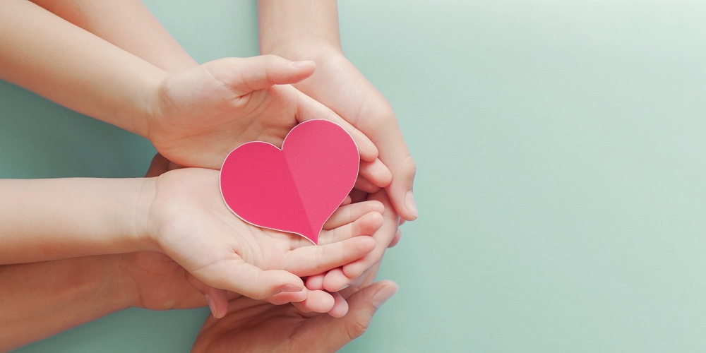 Family Hands Holding Red Heart