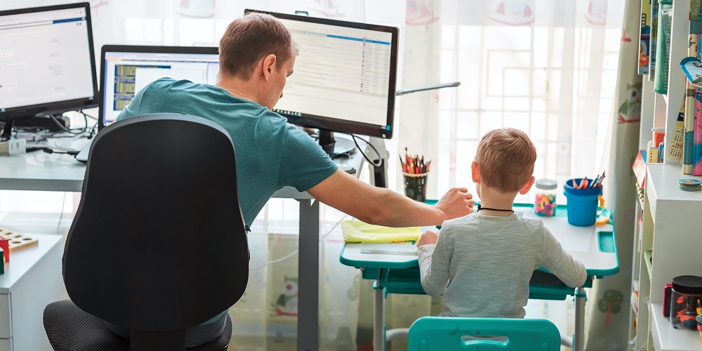 Father With Kid Working From Home During Quarantine. Stay At Home