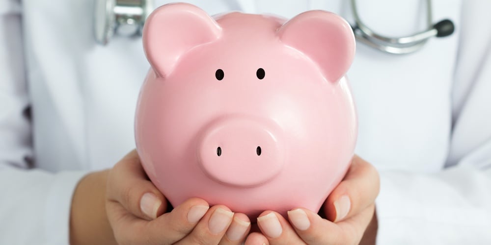 bigstock-Female-Doctor-Holding-Piggy-Ba-95848595