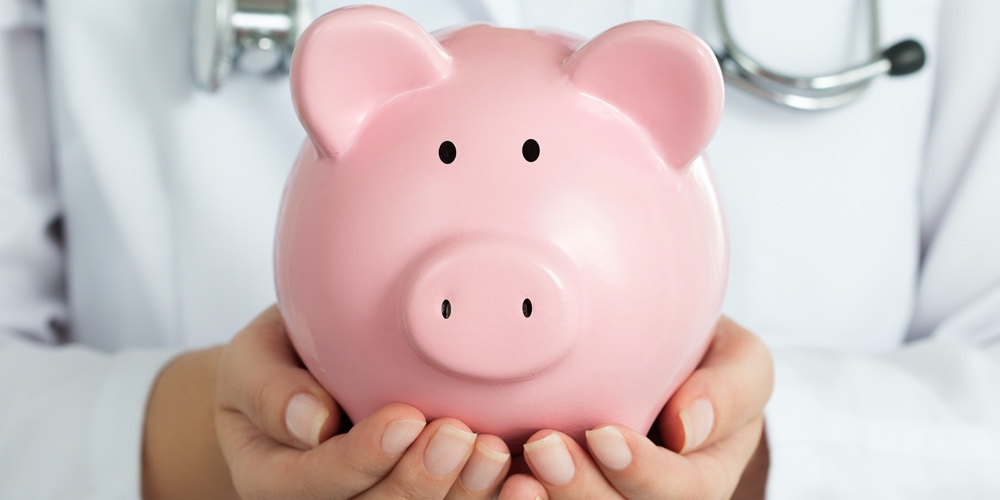 Female Doctor Holding Piggy Bank