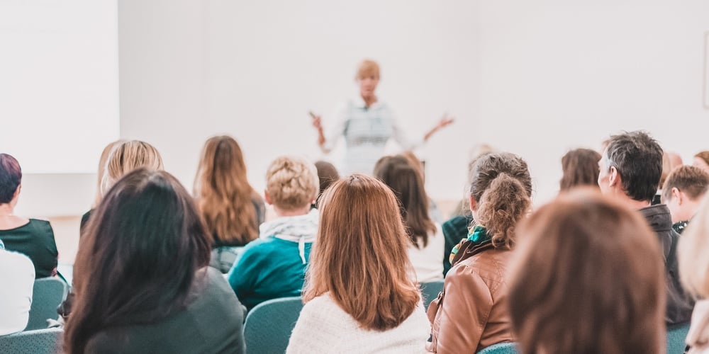 Female Speaker Giving A Talk At Business Meeting. Audience In Conference Hall. Business And Entrepre