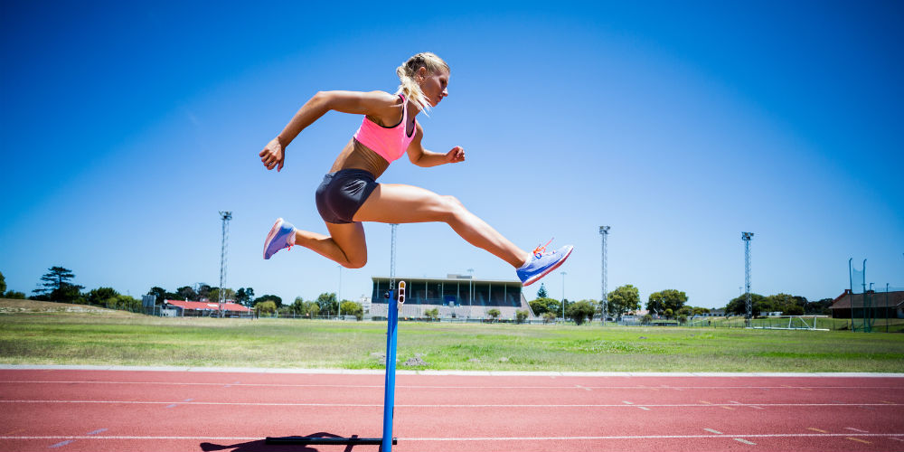 bigstock-Female-athlete-jumping-above-t-135666572
