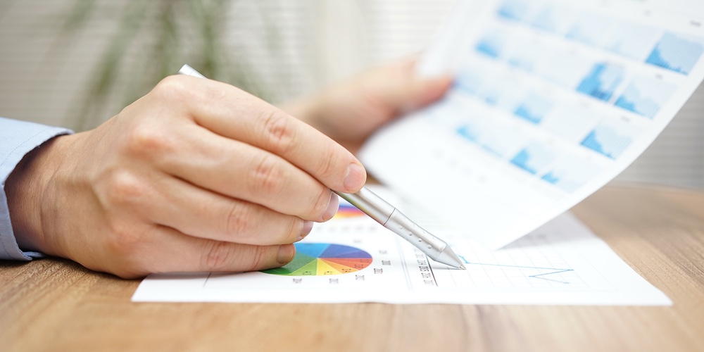Financial Adviser Is Reviewing Report With Charts And Graphs