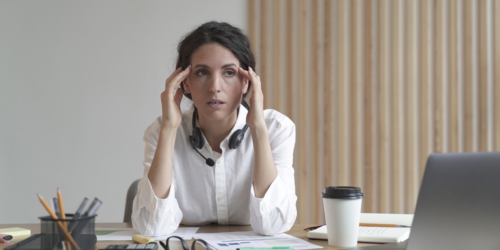Frustrated Business Woman Feeling Tired While Sitting At Table In Office
