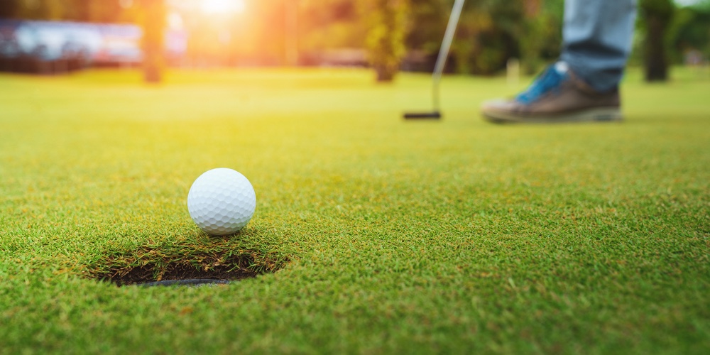 Golfer Putting Golf Ball On The Green Golf