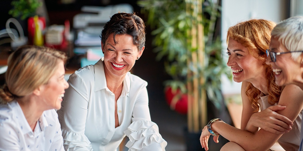 Group of cheerful business women have a good time while talking during a break in a friendly atmosph