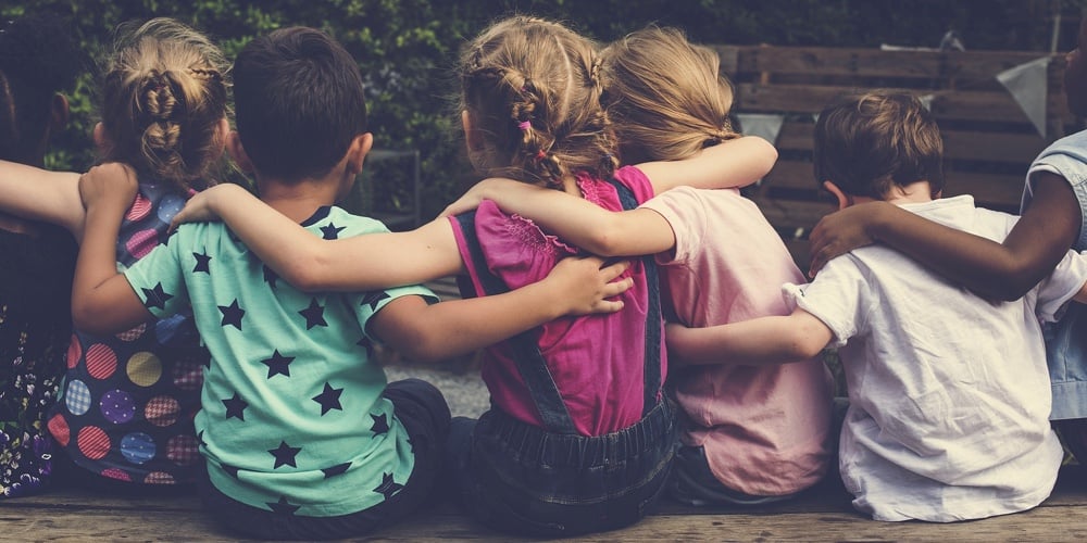 Group of kindergarten kids friends arm around sitting together
