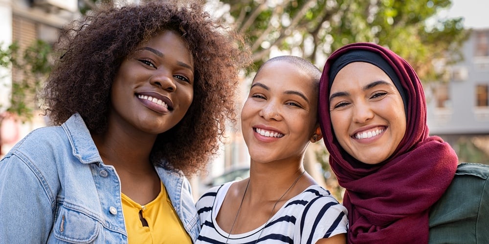 Multiracial Girlfriends Taking Selfie At Countryside Picnic – Happy Friendship Concept And Fun|Group of three happy multiethnic friends looking at camera. Portrait of young women of different cul