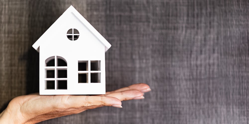 Hand Holding A House Model. Real Estate Agent Offer House