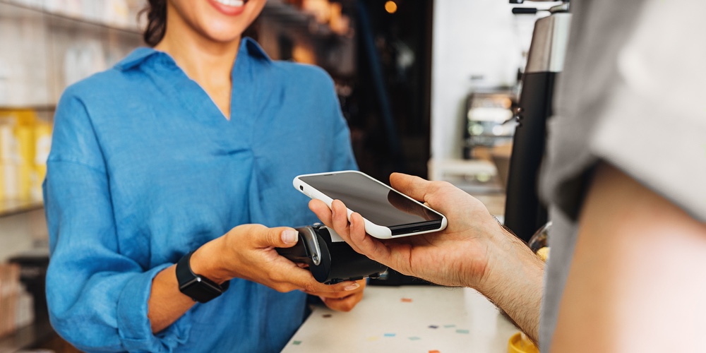 #1 Visa SMB_5.12.2021|#2 Visa Payments_5.12.2021|#3 Elavon_5.12.2021|Hand Of A Customer At A Cafe Paying His Bill Using A Mobile Phone. Female Entrepreneur Holding A Pos|#1 Visa SMB_5.24.2021|#2 Visa Payments_5.24.2021