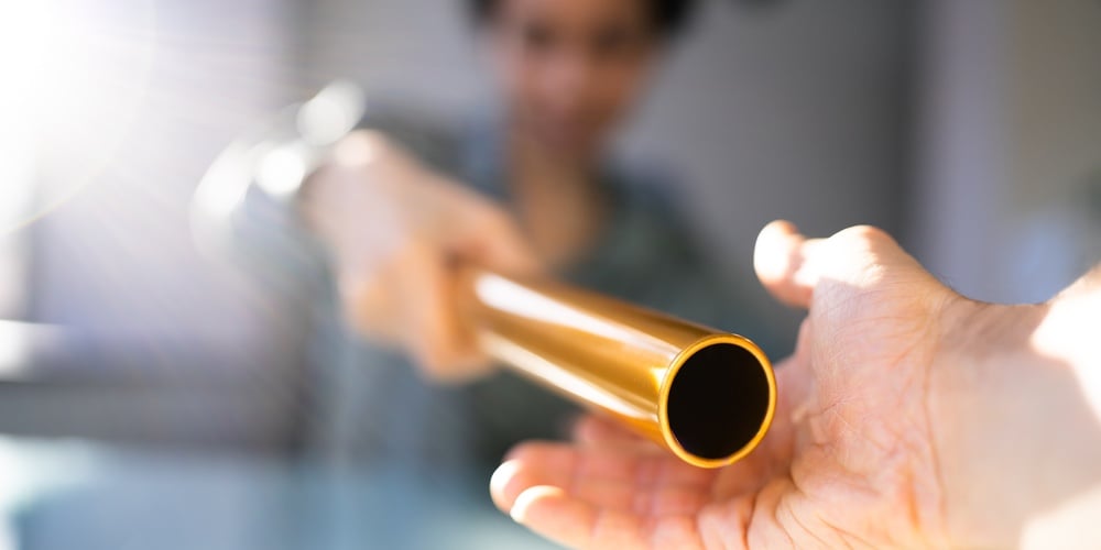 Hand Passing Golden Relay Baton To Businesswoman