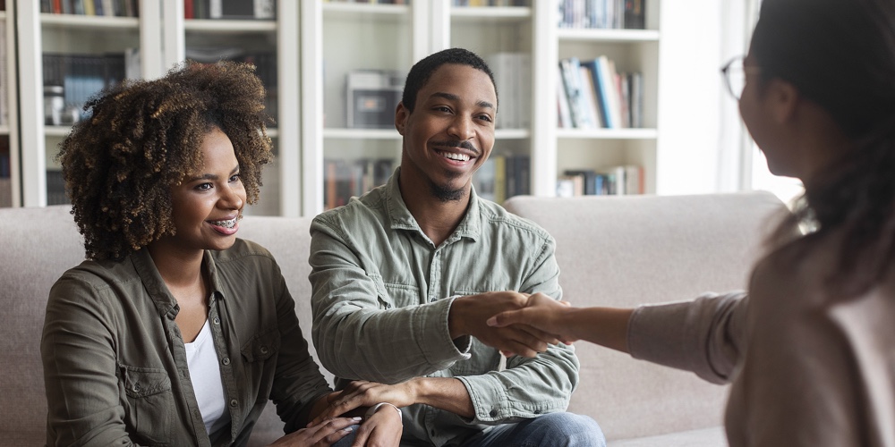 1|2|Happy African Couple Shaking Family Counselor Hand