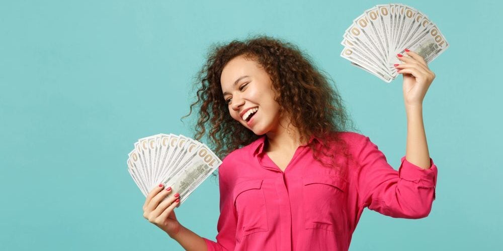 Happy African Girl In Casual Clothes Holding Fan Of Money In Dol