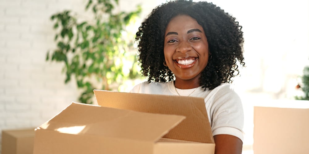 Happy African Young Woman With Cardboard Box Moving To A New Place