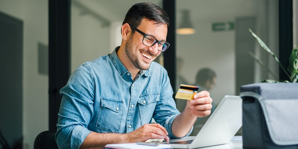 Happy Cheerful Smiling Young Adult Man Doing Online Shopping Or E-shopping Satisfied Entrepreneur Ma