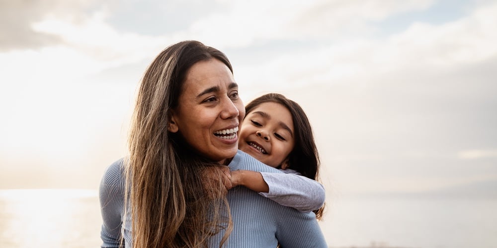 Happy Latin Mother Enjoying Time With Her Child On The Beach – Family And Love Concept