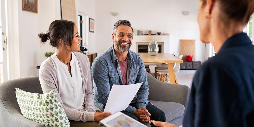 Happy mature couple discussing investments with financial broker during meeting at home. Middle east