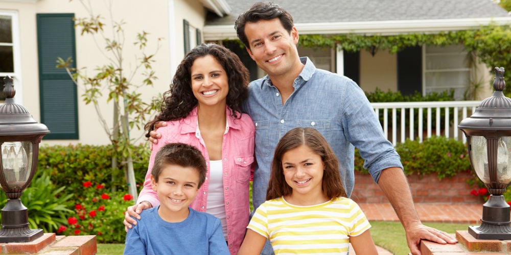 bigstock-Hispanic-family-outside-home-23443583