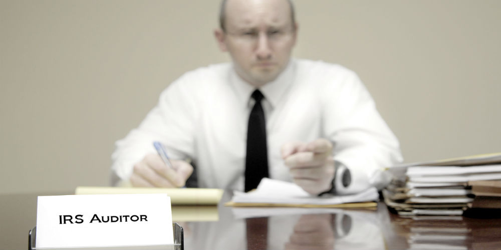 bigstock-IRS-tax-auditor-man-with-a-ste-82793822