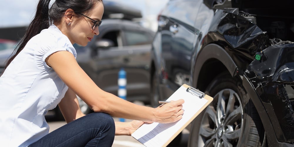 Insurance Agent Records Damage To Car After Accident. Car Insurance And Cash Compensation Concept