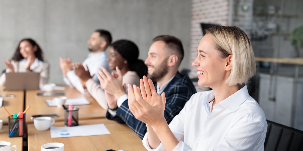 Joyful Coworkers Applauding Celebrating Business Success Sitting At Desk During Corporate Meeting In