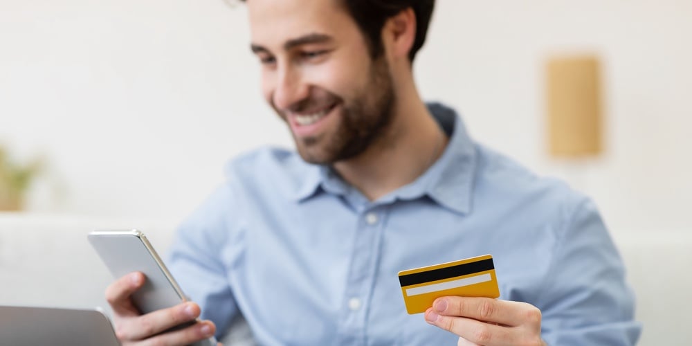bigstock-Joyful-Guy-Shopping-Online-Wit-399615812