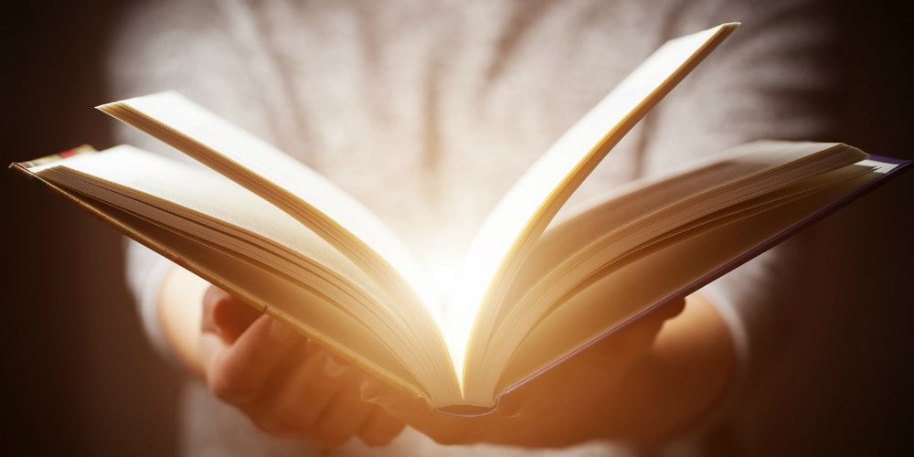 bigstock-Light-coming-from-book-in-woma-114743165