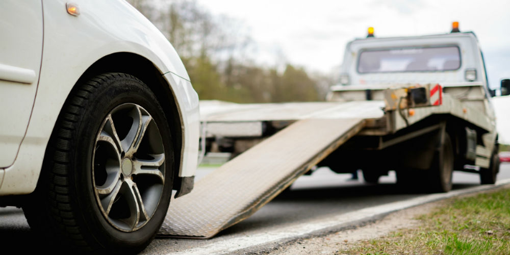 bigstock-Loading-broken-car-on-a-tow-tr-89815343