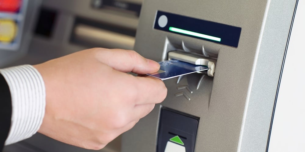 Male Hand Businessman Inserts Credit Card Into The Atm