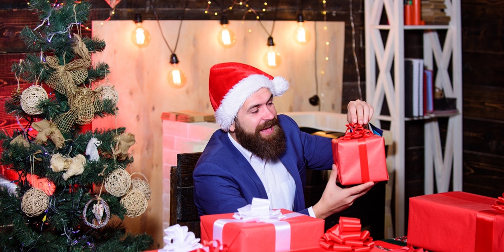 Man Bearded Santa Prepared Christmas Gifts. Businessman Near Christmas Tree Wrapping Presents Or Gif