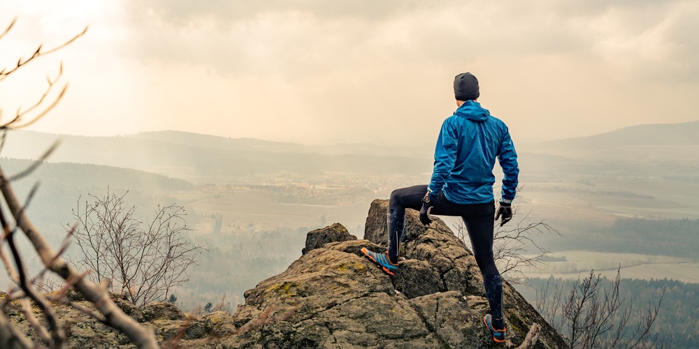 Man Celebrating Or Praying In Beautiful Inspiring Mountains Sunrise. Hiker Silhouette On Mountain To