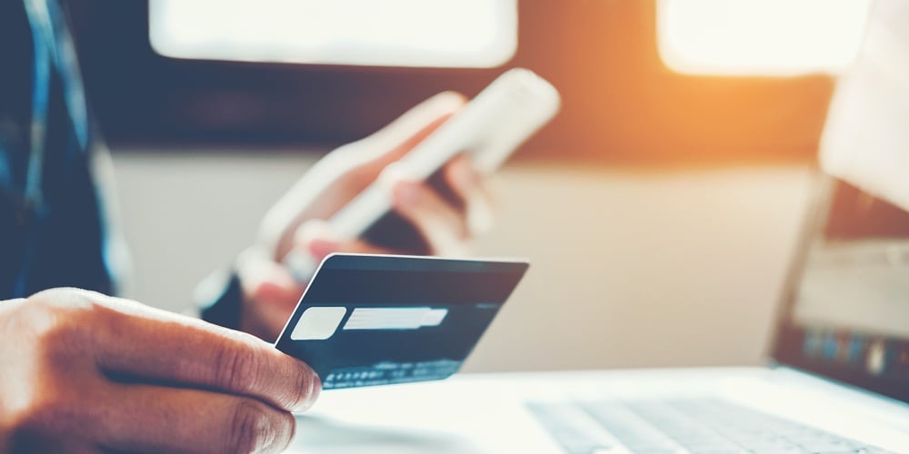 bigstock-Man-Holding-Credit-Card-And-Us-237319897