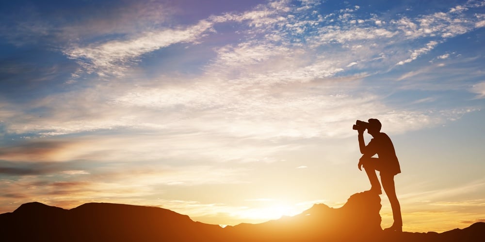 bigstock-Man-standing-on-rocks-looking-208080886