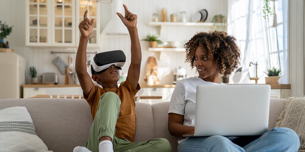 Modern Digital Family. Happy African American Family Mother And Son Resting On Sofa With Gadgets