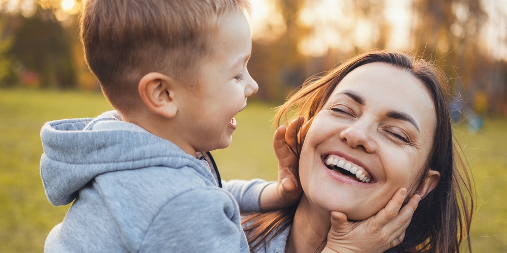 Mother And Her Child Enjoying The Early Spring Together In The Park. Smiling Happy Child. Happy Peop