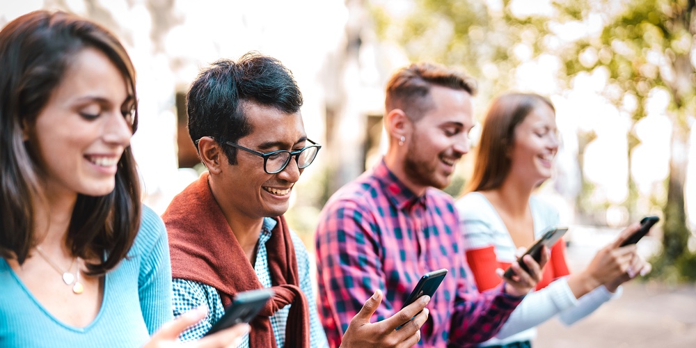 Multicultural Students Laughing Using Smartphone At University College Campus – Young People Friends