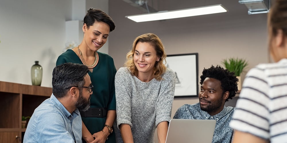 Multiethnic business people talking and smiling during meeting in office. Mature middle eastern man