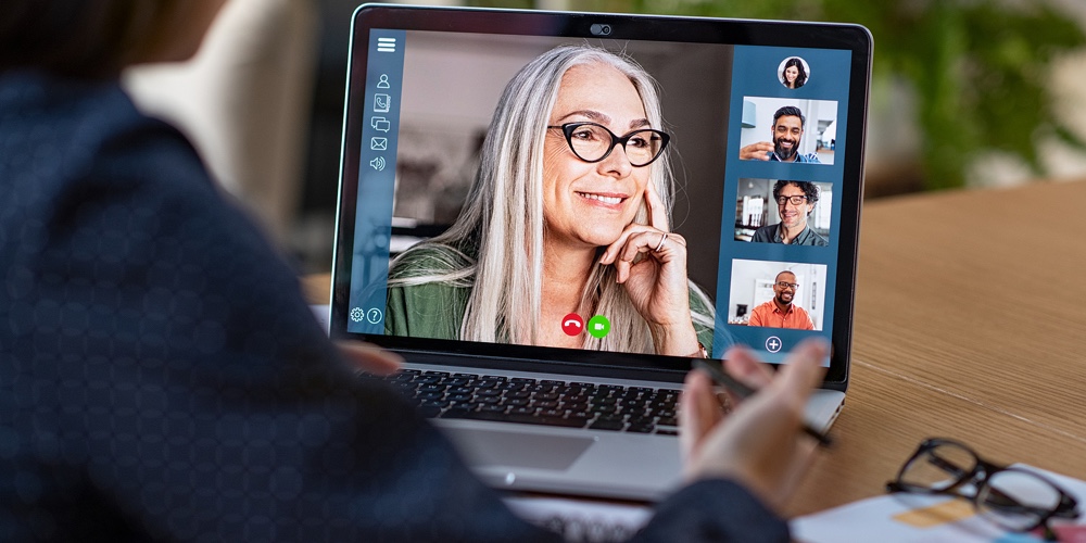 Multiethnic business team having discussion in video call. Rear view of business woman in video conf