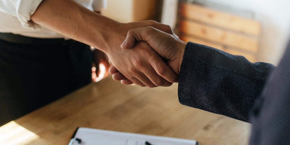 Partnership. Two Business People Shaking Hand After Business Signing Contract In Meeting Room At Com