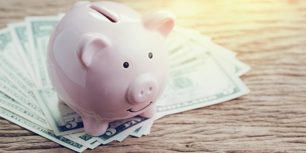 bigstock-Pink-Piggy-Bank-On-Pile-Of-Us-278519659