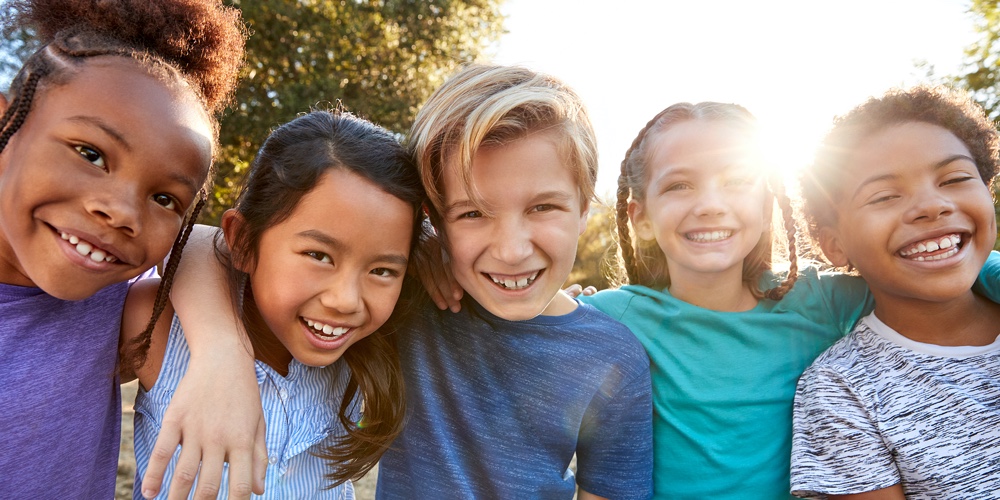 Portrait Of Multi-Cultural Children Hanging Out With Friends In Countryside Together
