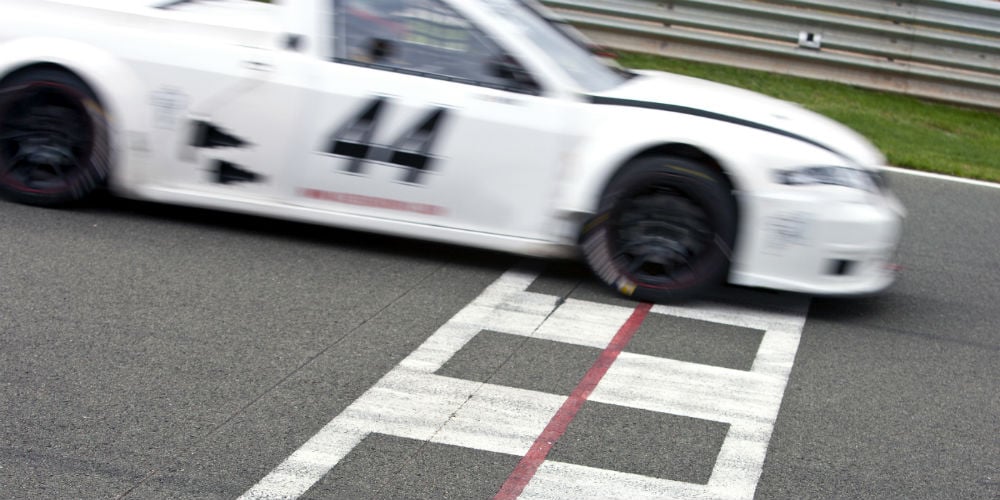 bigstock-Race-car-crossing-the-finish-l-68486779